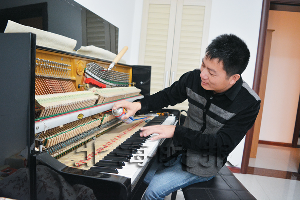 陈耀冰正在为钢琴调律。 谭华懿 摄